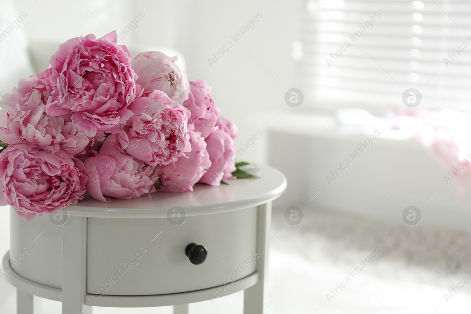 Photo of Bunch of beautiful peonies on table indoors. Space for text
