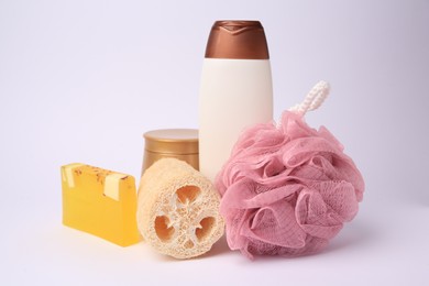 Photo of Pink shower puff, loofah sponge and cosmetic products on white background