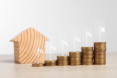 Image of Mortgage rate. Stacked coins, arrows, percent signs and model of house