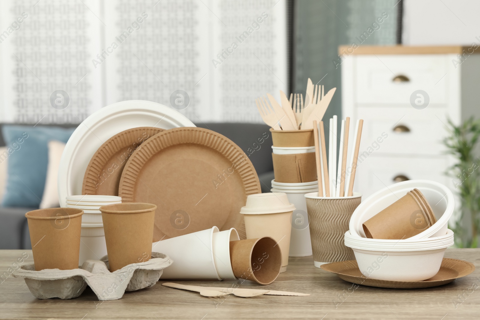 Photo of Set of eco disposable tableware on wooden table indoors