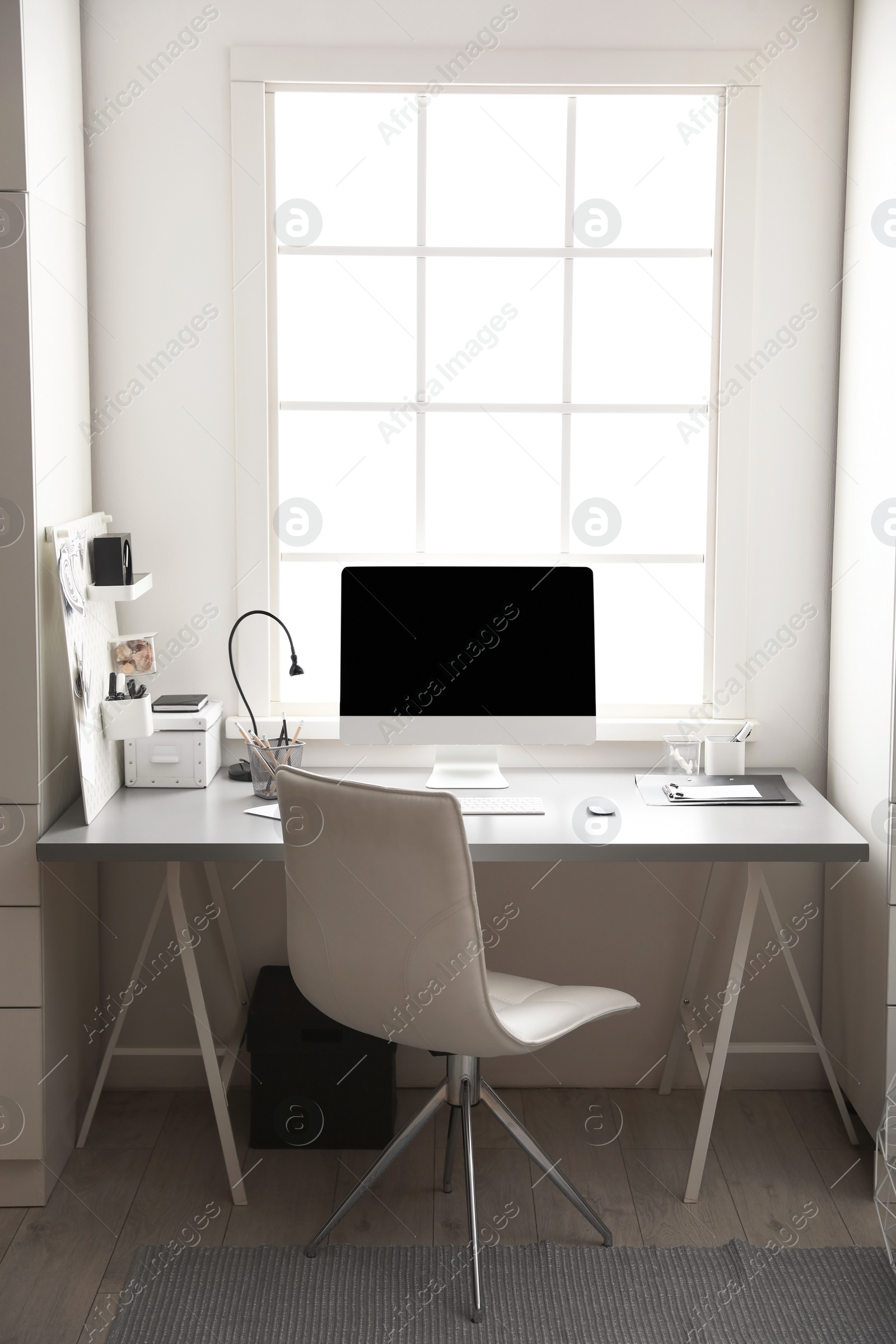 Photo of Light work place with computer near window. Interior design