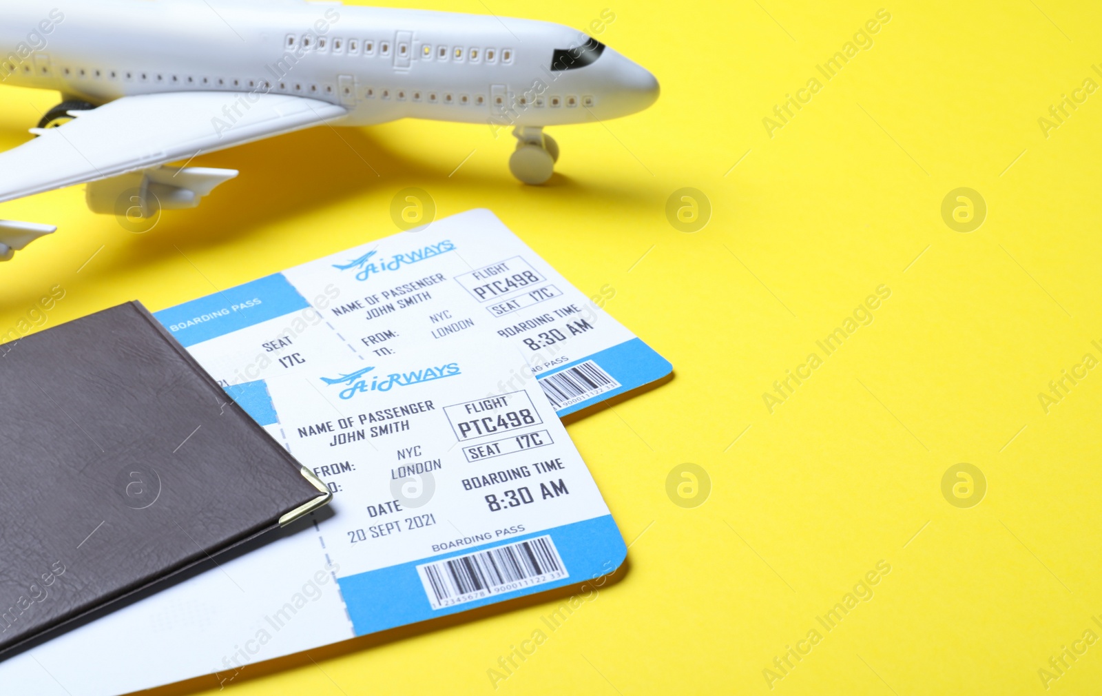 Photo of Passport with tickets and toy airplane on yellow background, space for text. Travel agency concept