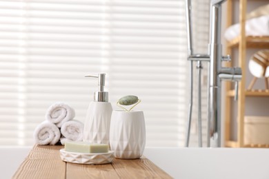 Photo of Different personal care products on bath tub in bathroom