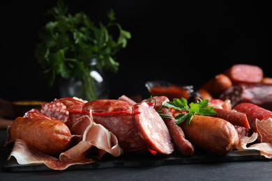 Photo of Different types of sausages served on black table. Space for text
