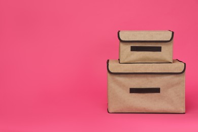 Two textile storage cases on pink background. Space for text