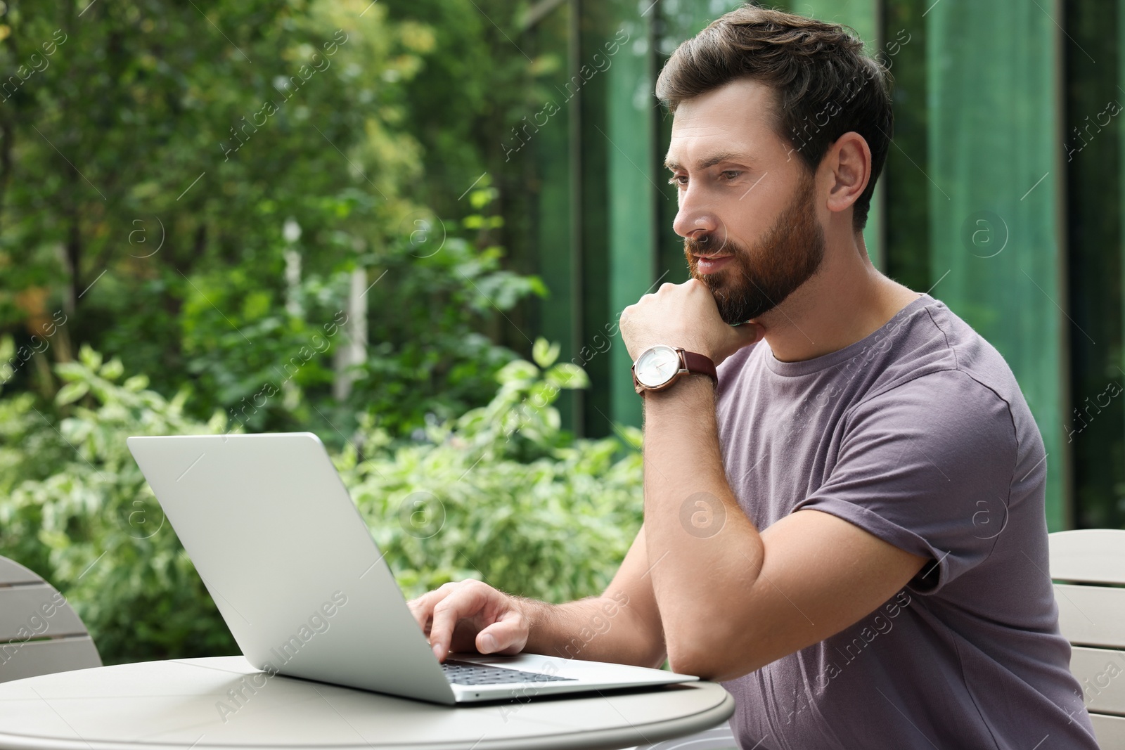 Photo of Handsome man with laptop in outdoor cafe