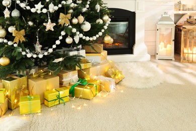 Decorated Christmas tree with gift boxes and fireplace in room