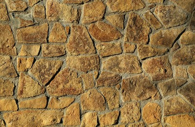 Photo of Texture of concrete wall decorated with stones as background, closeup