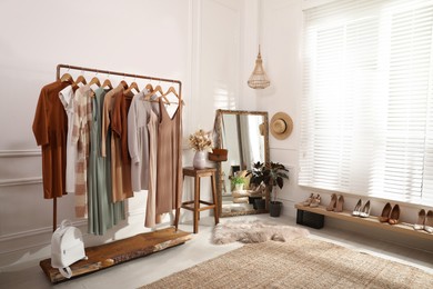 Dressing room interior with stylish clothes, shoes and accessories