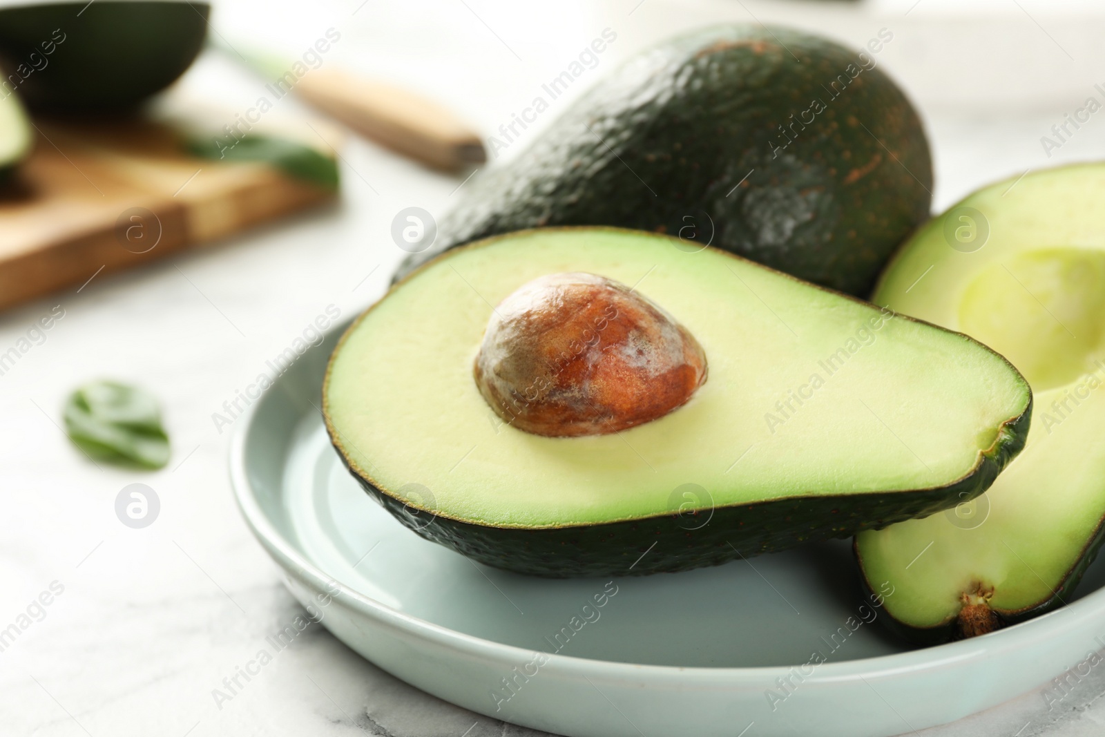 Photo of Delicious ripe avocados on white table, closeup