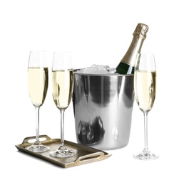 Glasses with champagne and bottle in bucket on white background