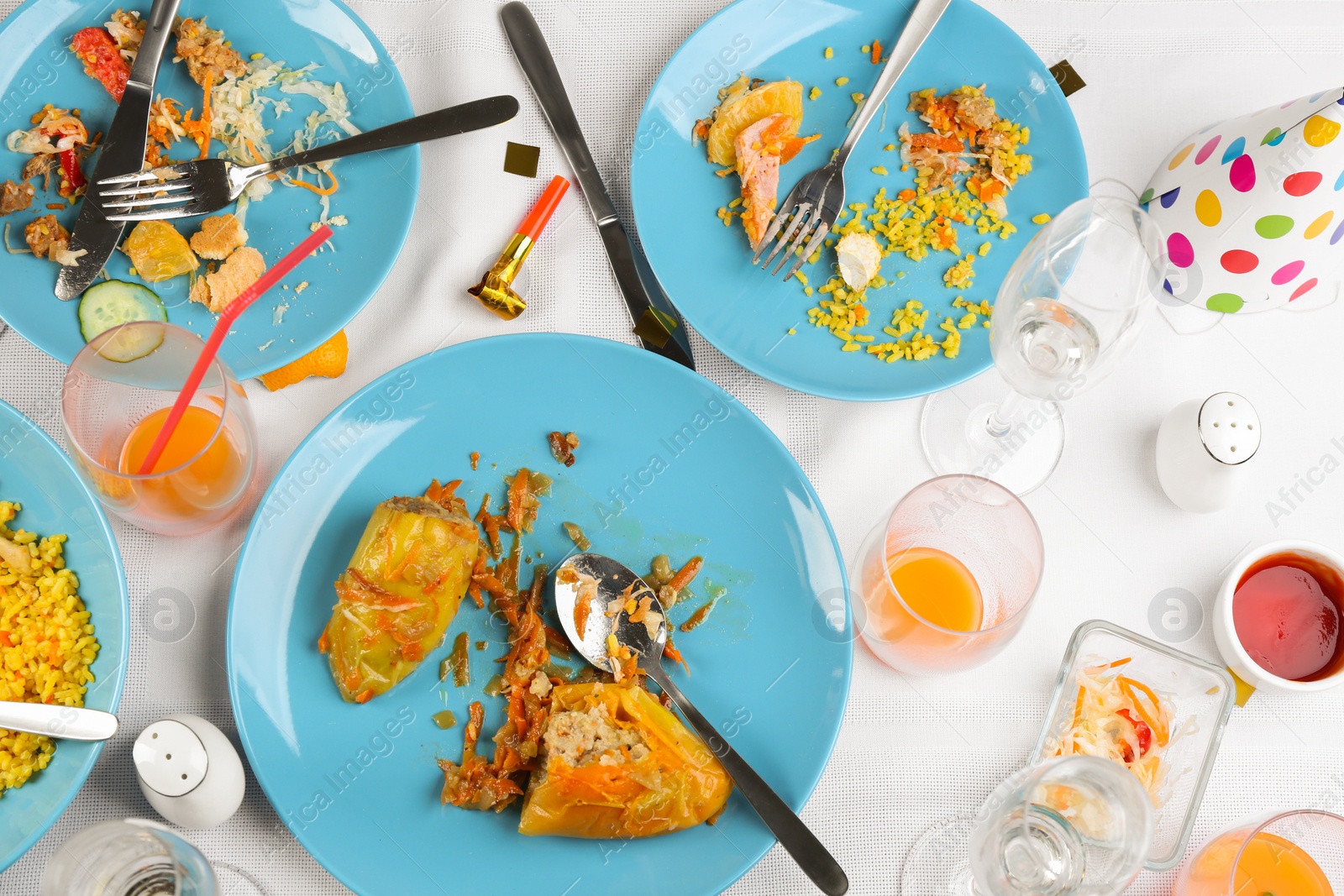 Photo of Flat lay composition with food leftovers on white tablecloth after party