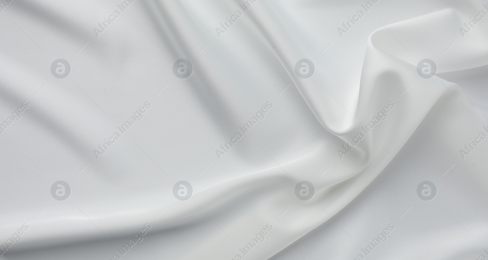 Photo of Texture of crumpled white silk fabric as background, top view