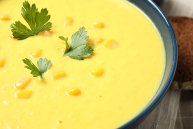 Photo of Delicious creamy corn soup with parsley in bowl, closeup