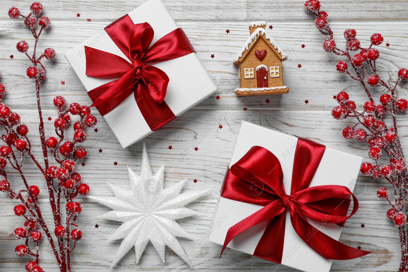 Photo of Flat lay composition with beautiful gift boxes and different Christmas decor on white wooden table