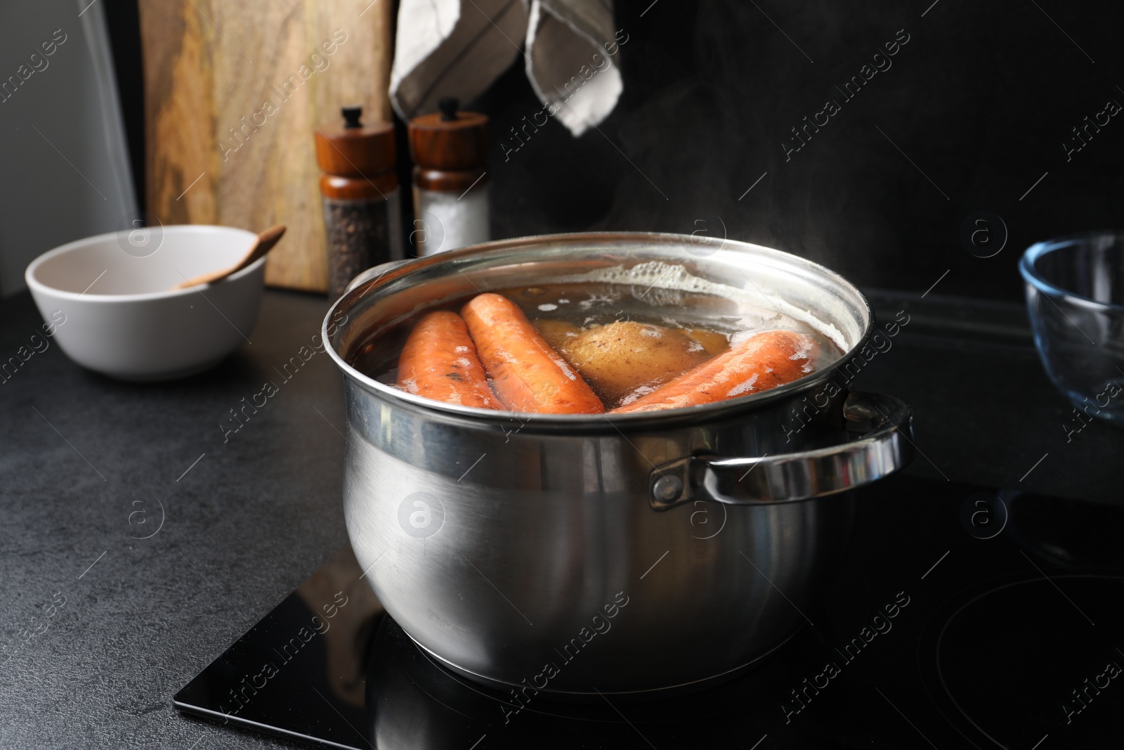 Photo of Boiling carrot and potatoes in pot on electric stove. Cooking vinaigrette salad