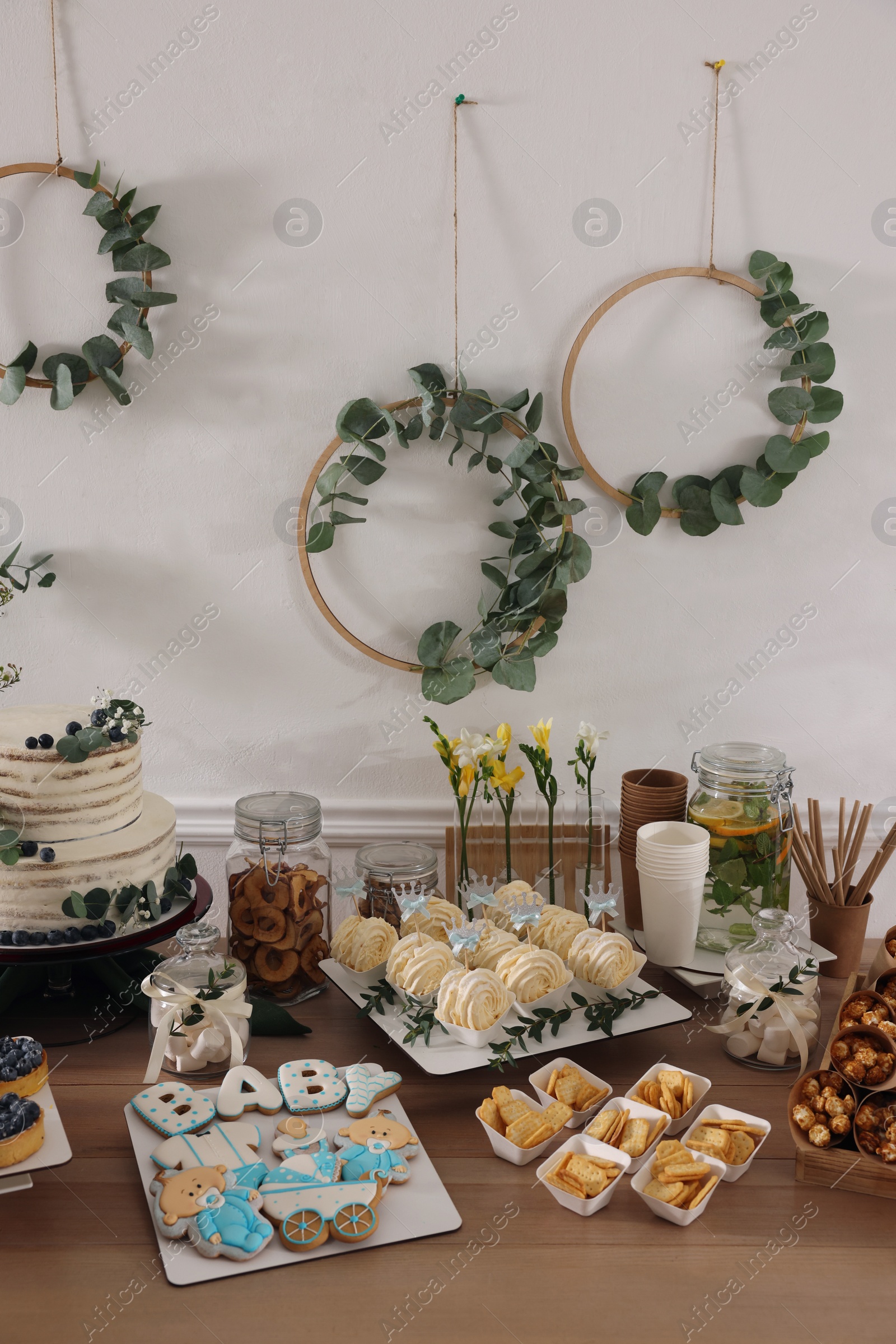 Photo of Beautiful cake and other treats on table in room. Baby shower party