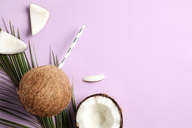 Photo of Creative composition with summer refreshing cocktail in coconut on lilac background, space for text