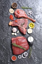 Photo of Fresh raw beef cuts and different spices on grey textured table, flat lay