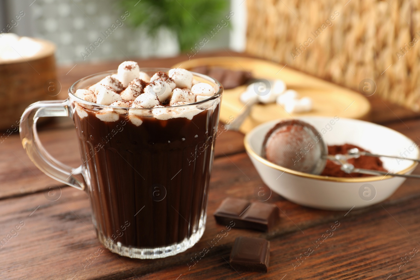 Photo of Cup of aromatic hot chocolate with marshmallows and cocoa powder on wooden table, closeup. Space for text