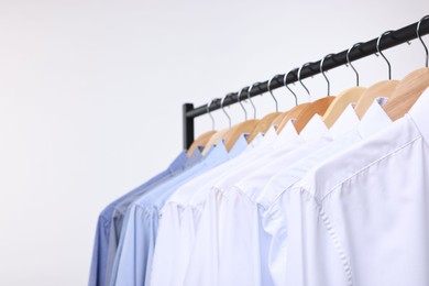 Photo of Dry-cleaning service. Many different clothes hanging on rack against white background, space for text