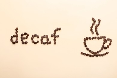 Photo of Cup of coffee and word Decaf made with beans on beige background, flat lay