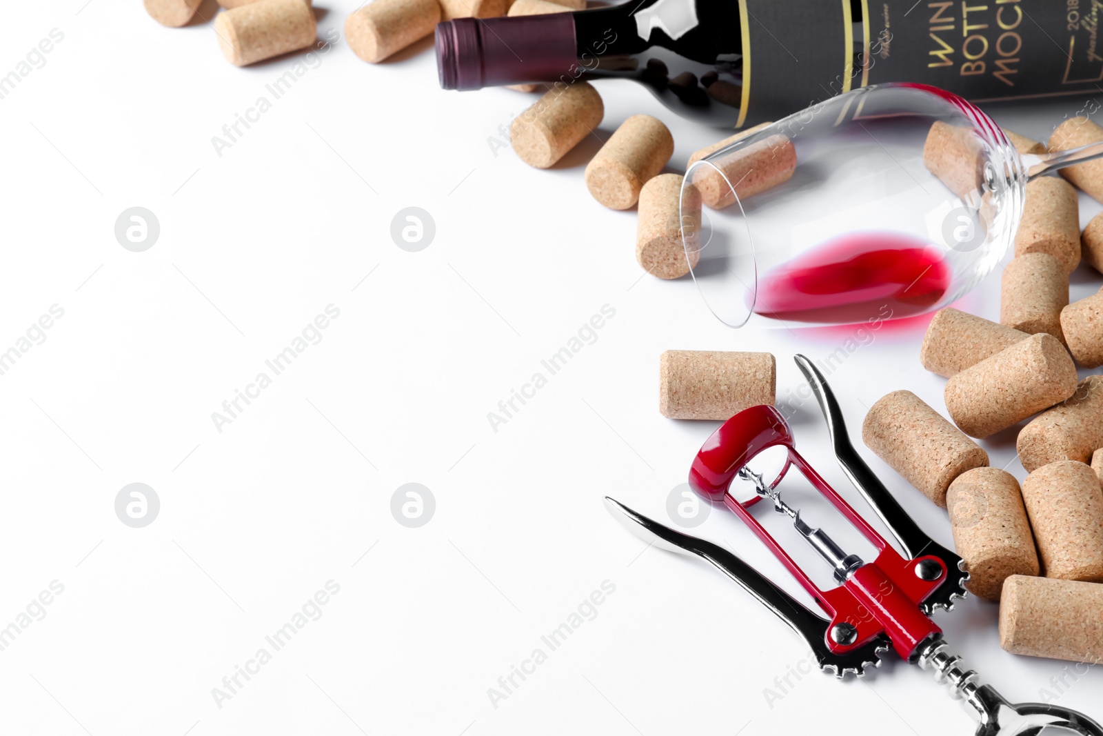 Photo of Corkscrew with wine bottle, glass and stoppers on white background