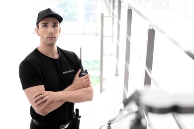 Male security guard with portable radio transmitter indoors