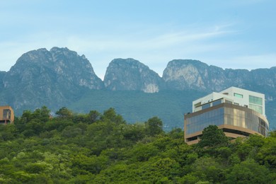 Beautiful view of building and green plants near mountains