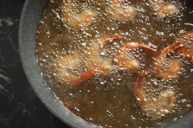 Cooking delicious shrimps in hot oil, top view