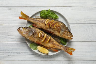 Tasty homemade roasted perches on white wooden table, top view. River fish