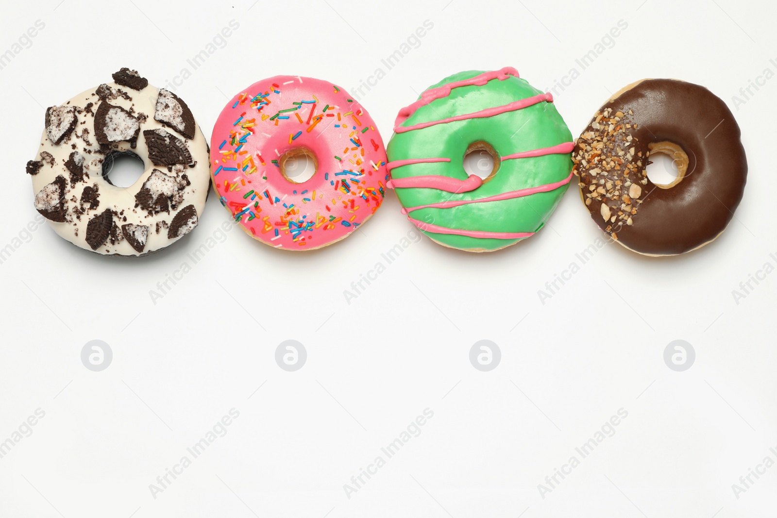 Photo of Different delicious glazed doughnuts on white background, top view