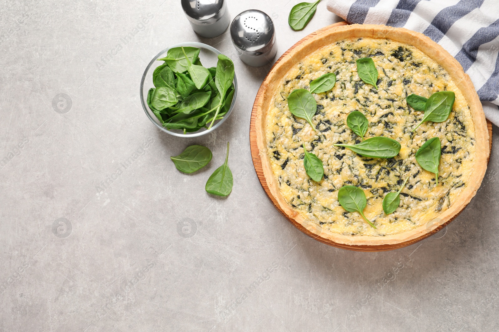 Photo of Delicious homemade spinach pie on light grey table, flat lay. Space for text