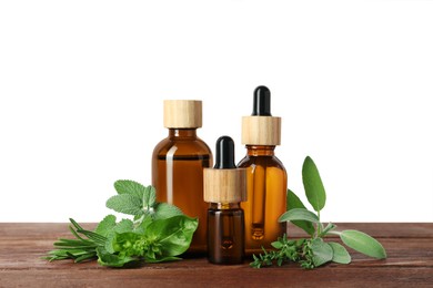 Photo of Bottles of essential oil and fresh herbs on wooden table against white background