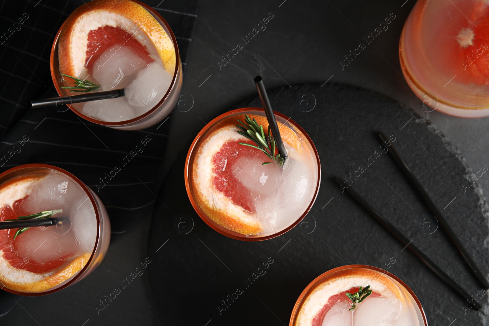 Photo of Flat lay composition with glasses of grapefruit cocktails on grey background