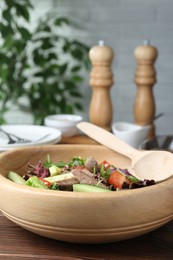 Photo of Delicious salad with beef tongue, vegetables and spoon served on wooden table