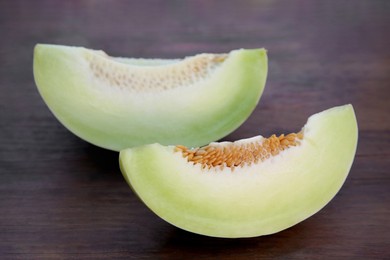 Photo of Cut tasty ripe melon on wooden table