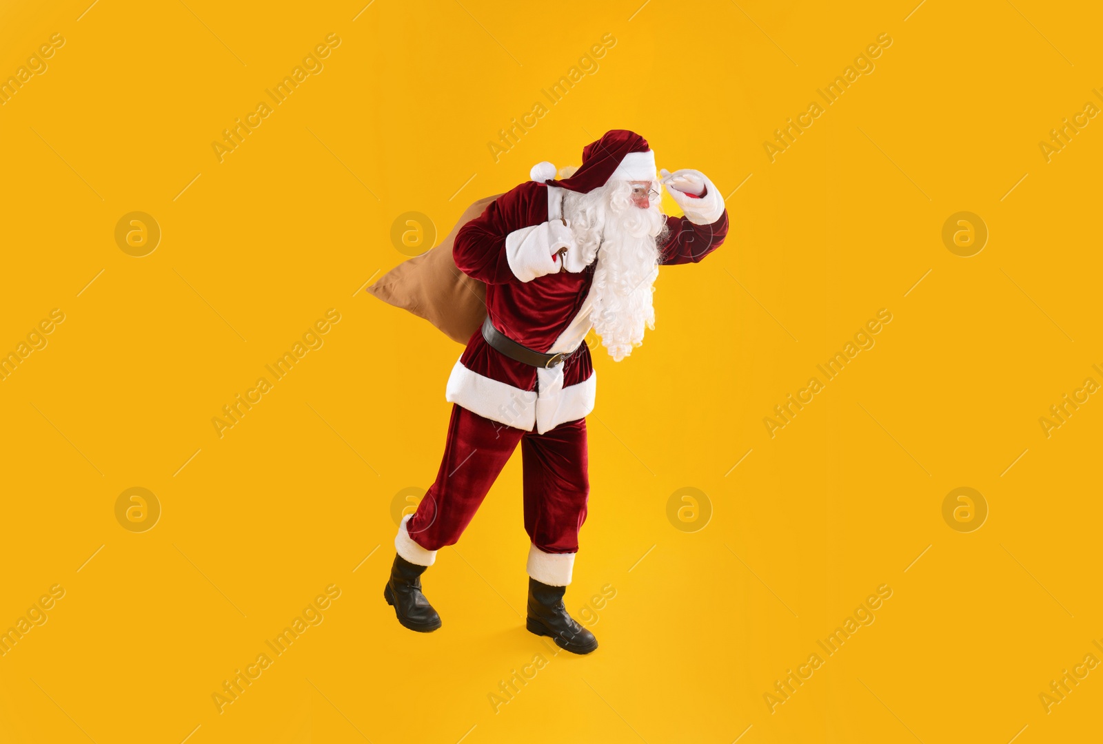 Photo of Full length portrait of Santa Claus with sack on yellow background