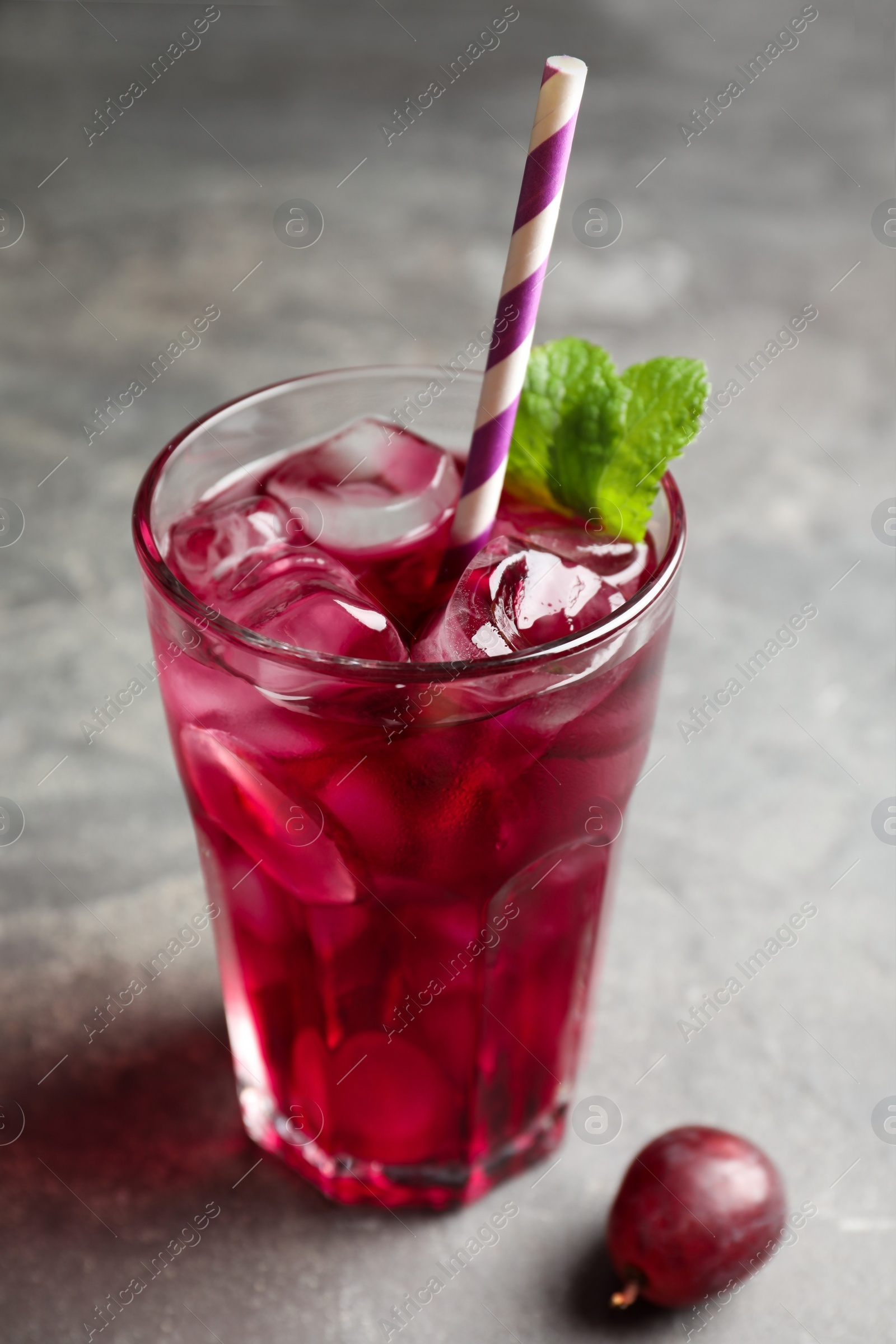 Photo of Delicious grape soda water on grey table. Refreshing drink