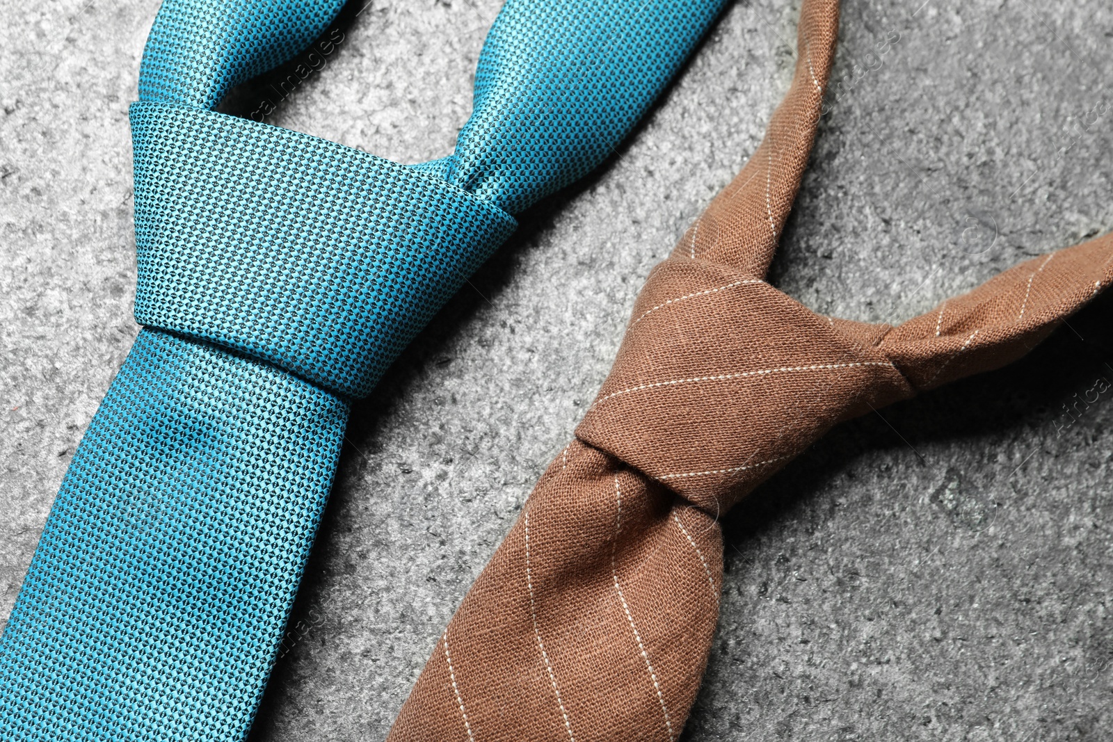 Photo of Two neckties on grey textured background, closeup