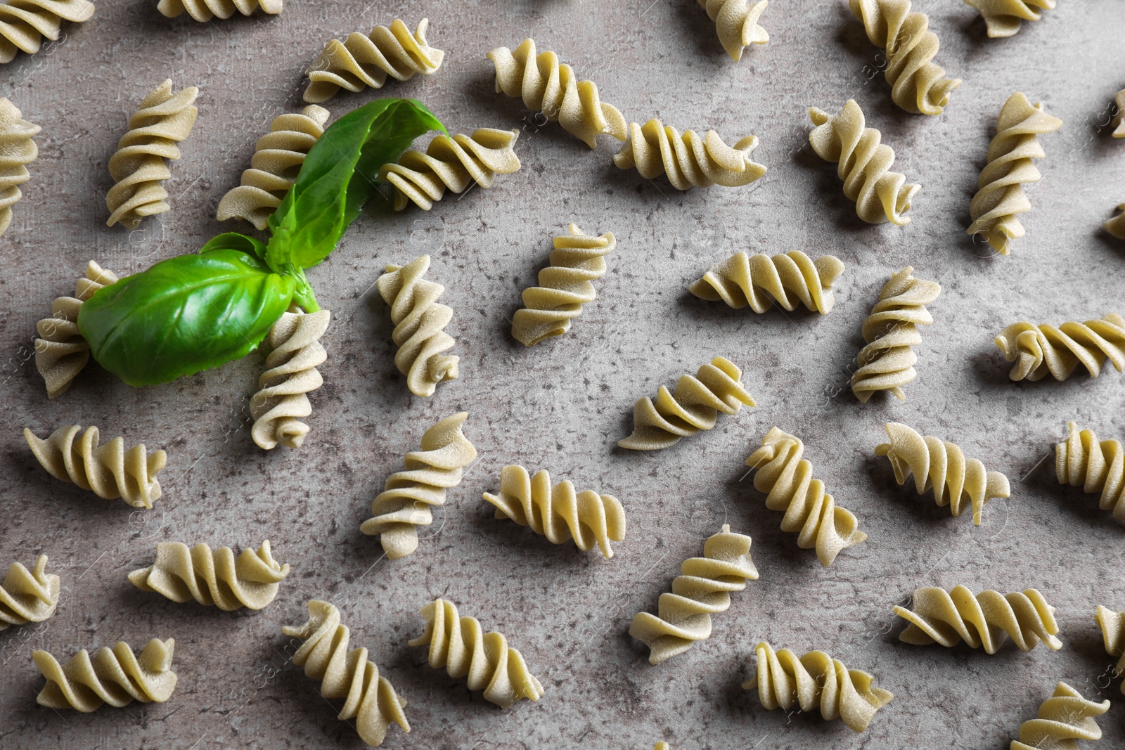 Photo of Uncooked garganelli pasta on grey table, flat lay