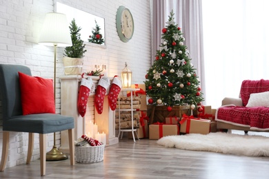 Photo of Stylish interior with beautiful Christmas tree and decorative fireplace