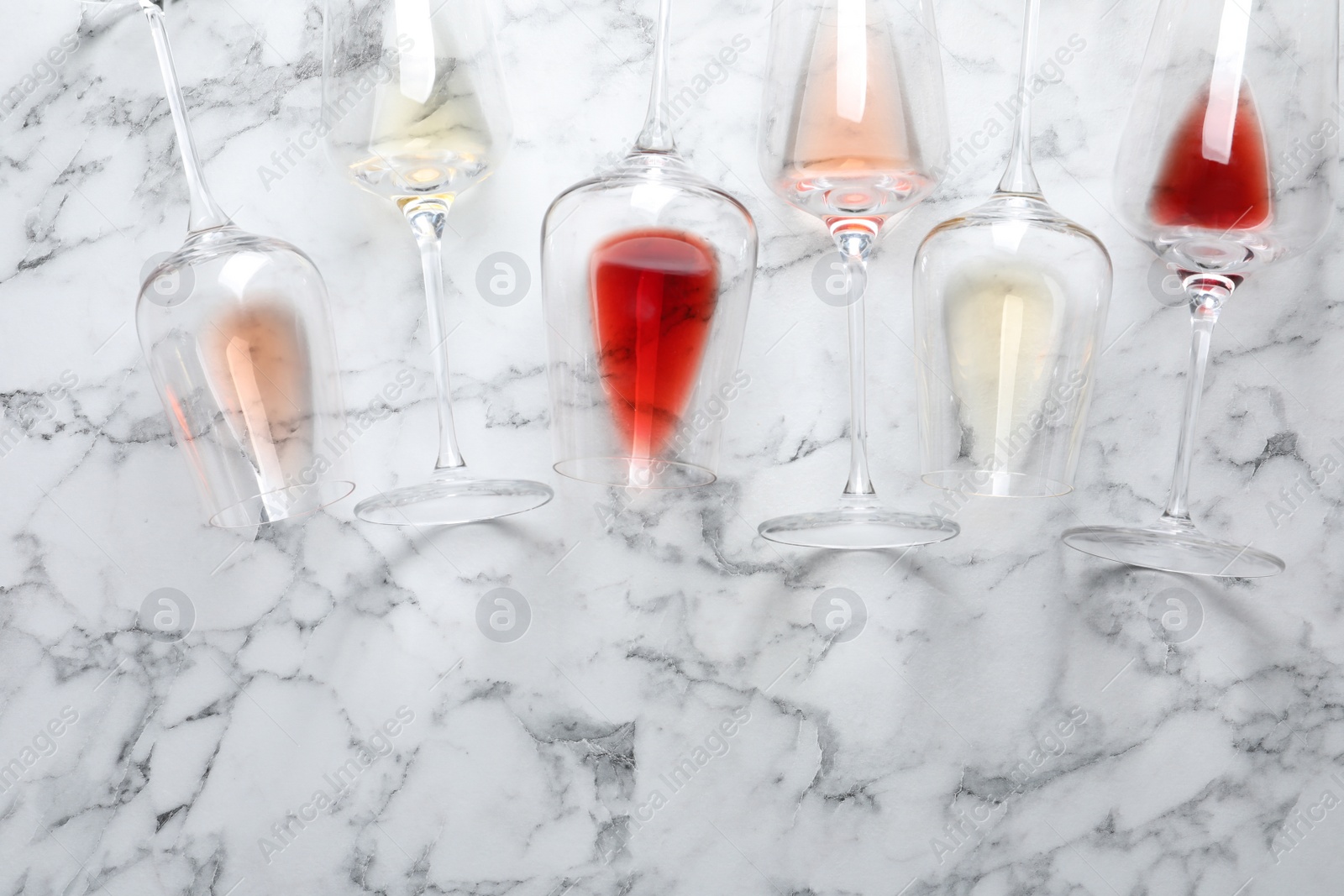 Photo of Glasses with different wine on marble background, flat lay. Space for text