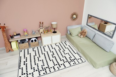 Photo of Montessori bedroom interior with floor bed and toys