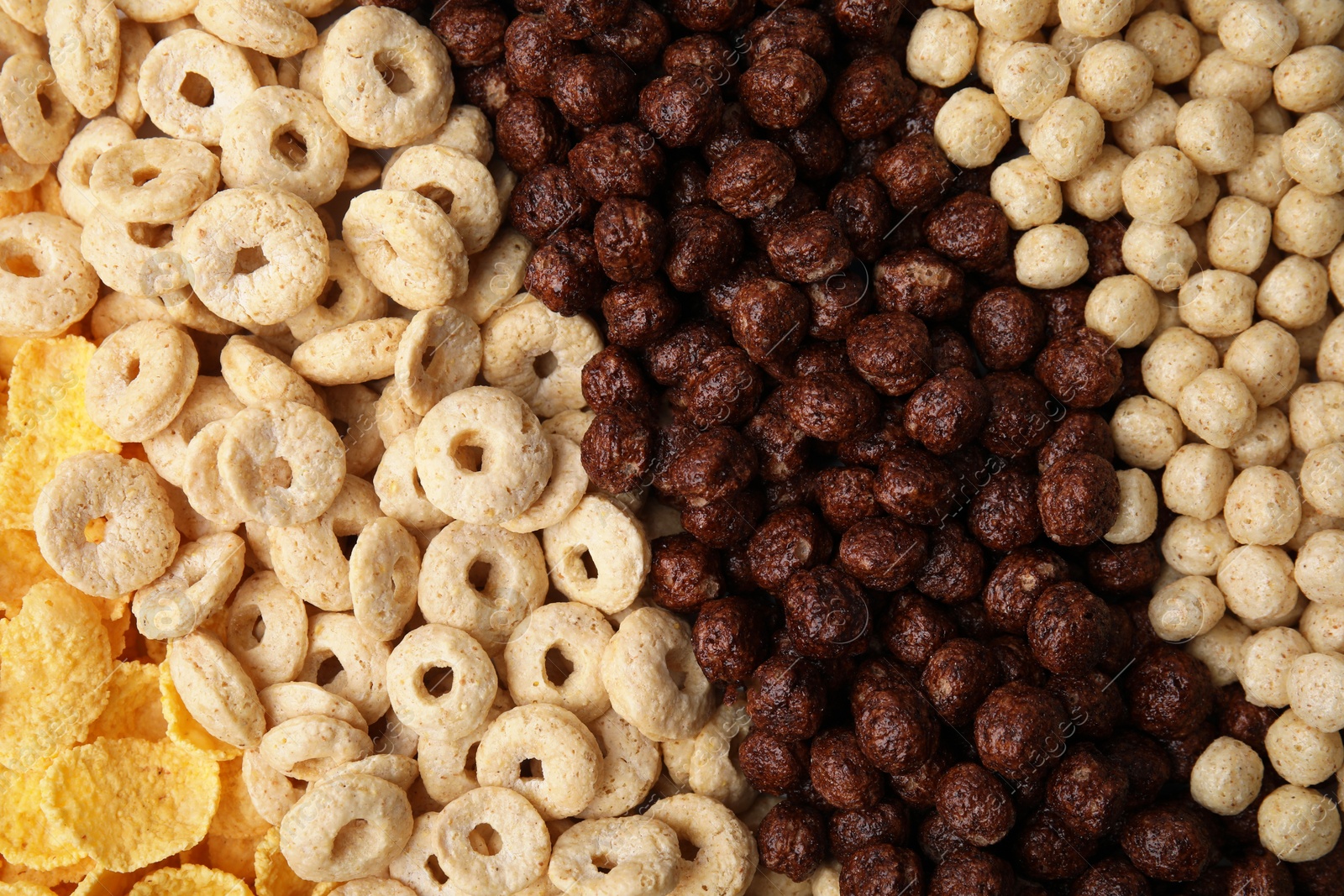 Photo of Different types of breakfast cereals as background, top view