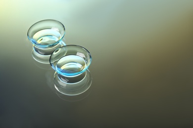 Photo of Contact lenses on color background