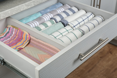 Photo of Open drawer with folded towels. Order in kitchen