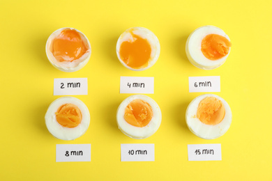 Photo of Different cooking time and readiness stages of boiled chicken eggs on yellow background, flat lay