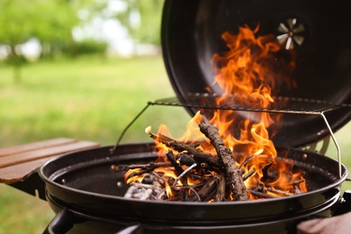 Modern barbecue grill with fire flames outdoors