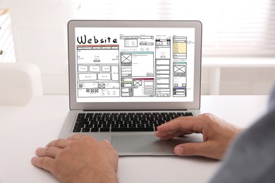 Image of Designer creating website on laptop at white table, closeup